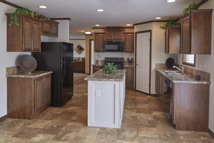 Kitchen in Montclair model. Tile floors, dark wood cabinets, and island